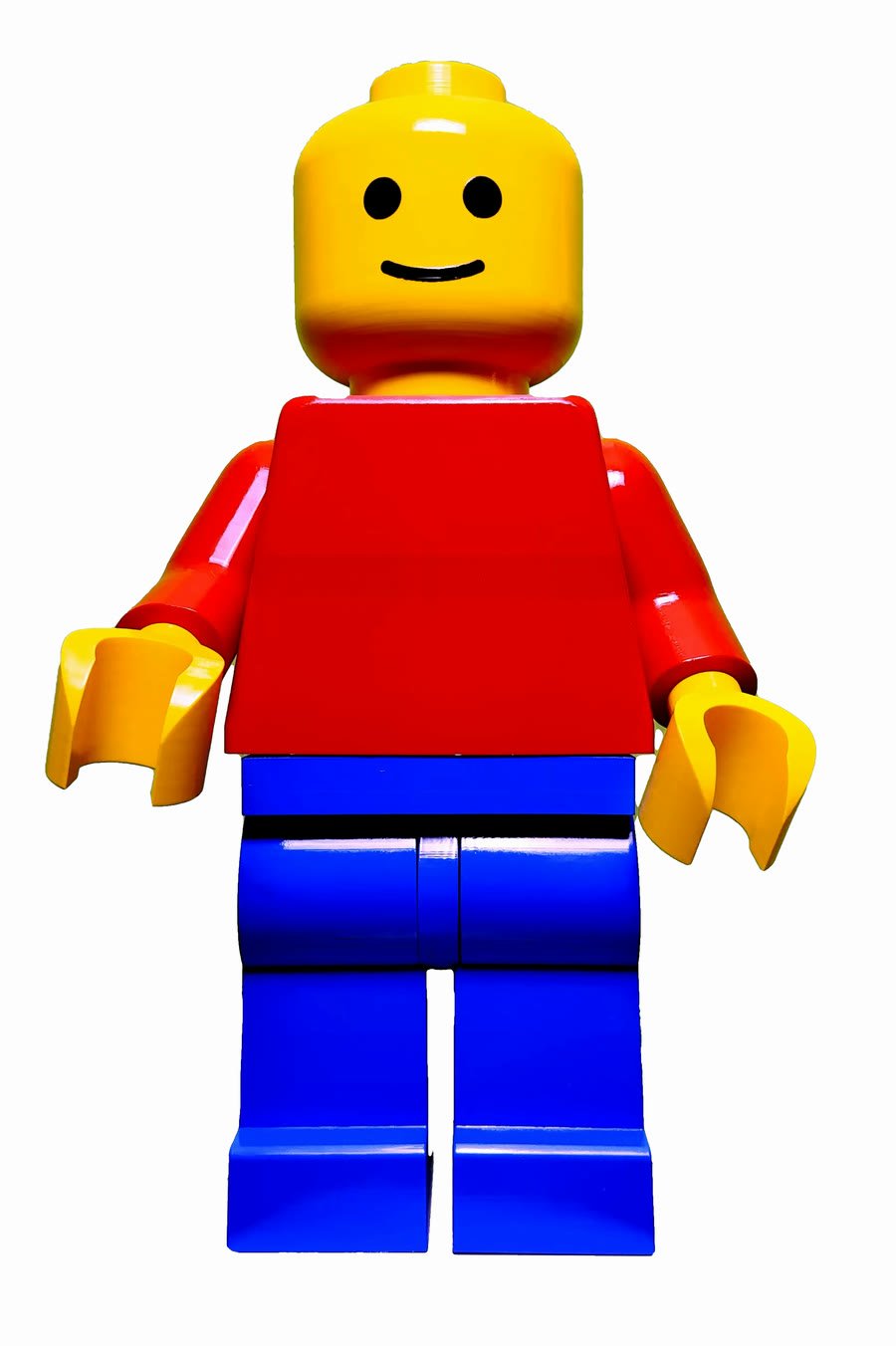 The Classic Mega Figure in high gloss — yellow head, red torso and arms, cobalt legs — with the plain chest it ships with, photographed against white