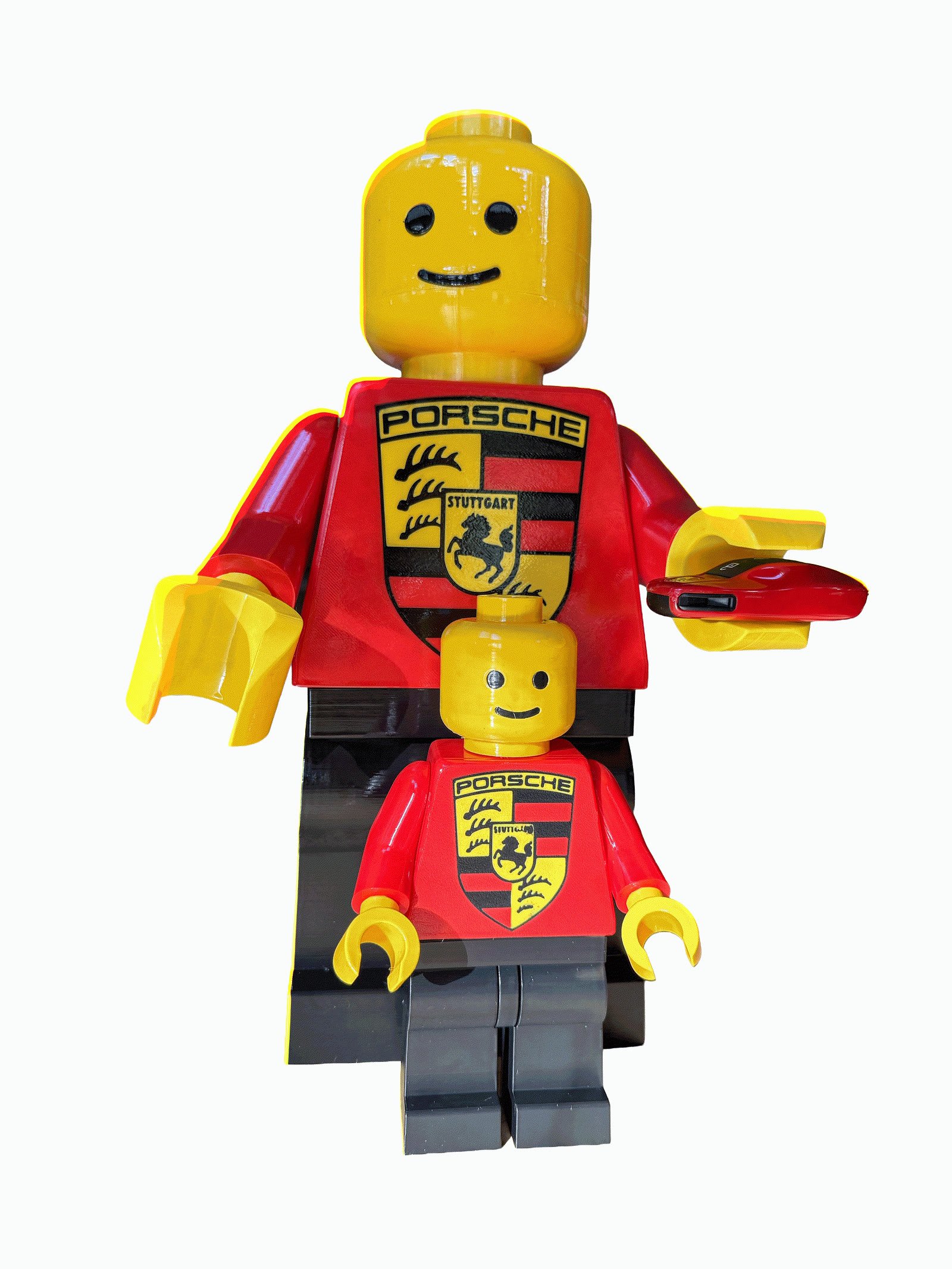 A 16-inch and an 8-inch Mega Figure in matching gloss racing liveries, the smaller standing in front of the larger, with a car key resting in the larger one’s open hand