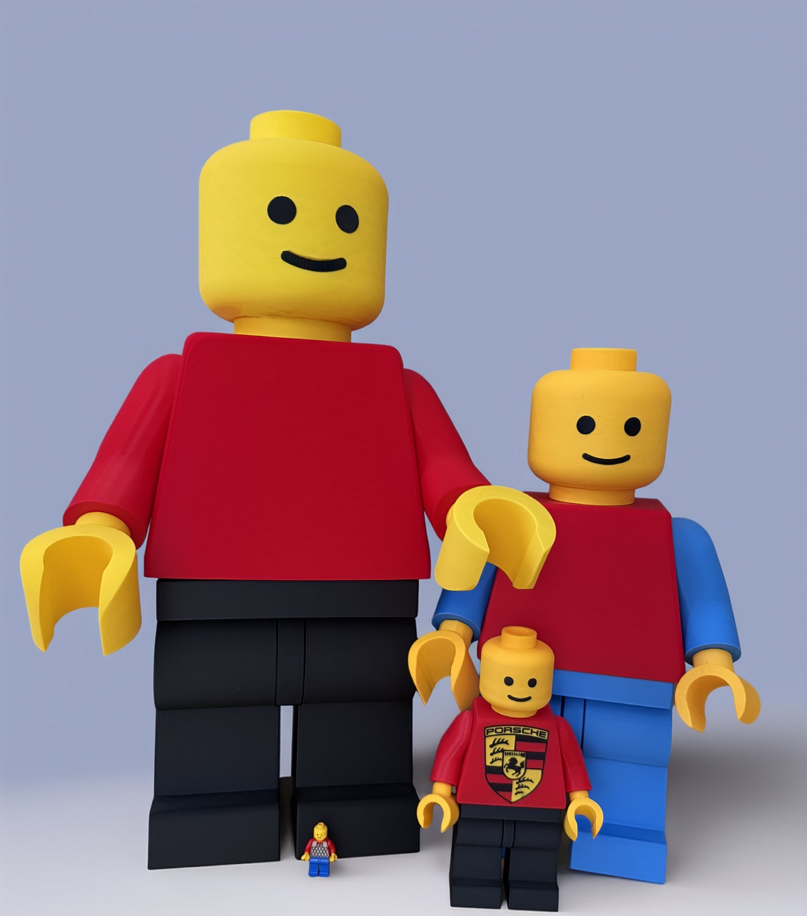 The 24-inch, 16-inch and 8-inch figures standing together beside a standard minifigure, showing the three sizes side by side