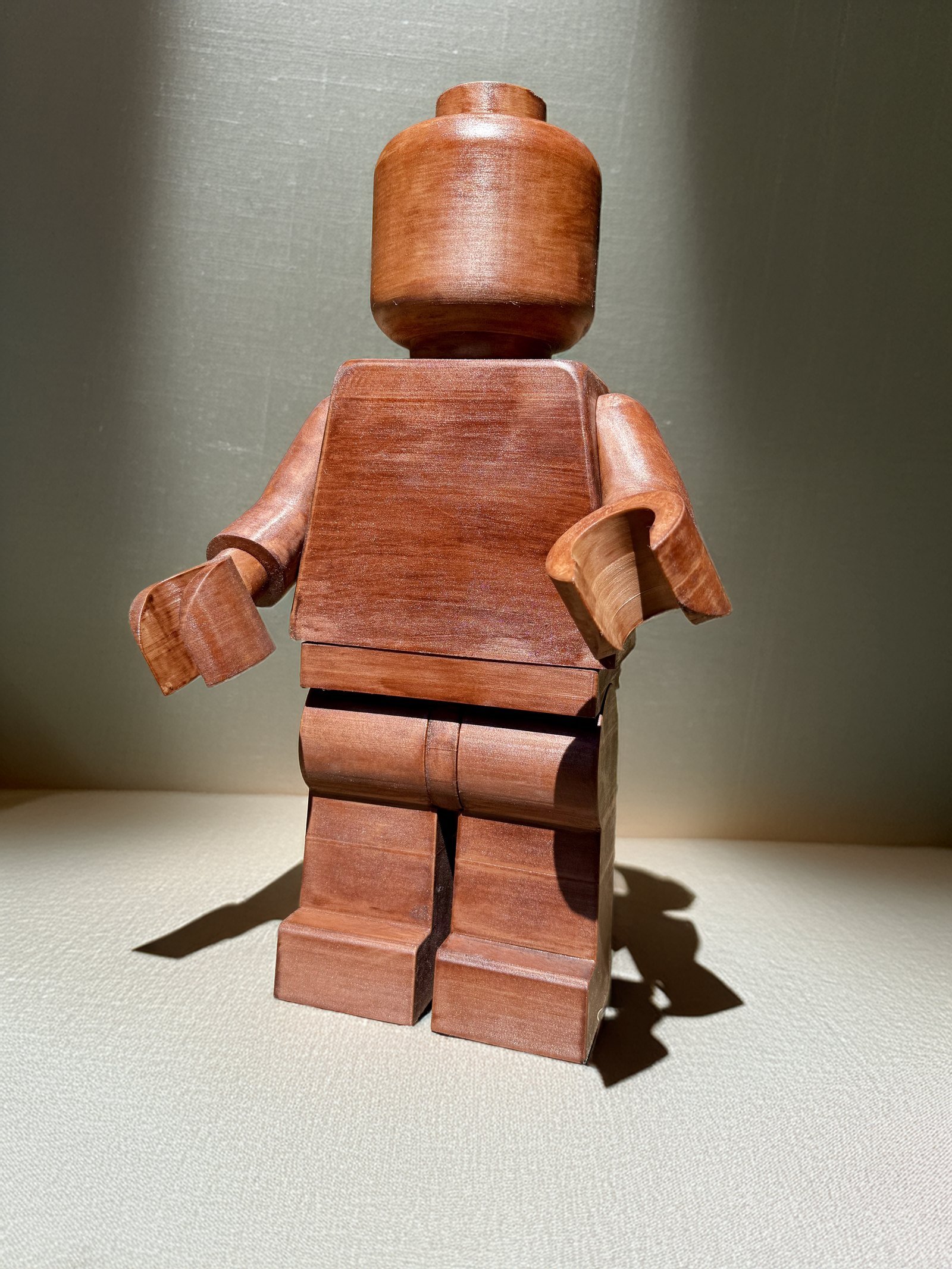 A Mega Figure printed in wood-filled filament and stained American Walnut, the grain visible across the torso