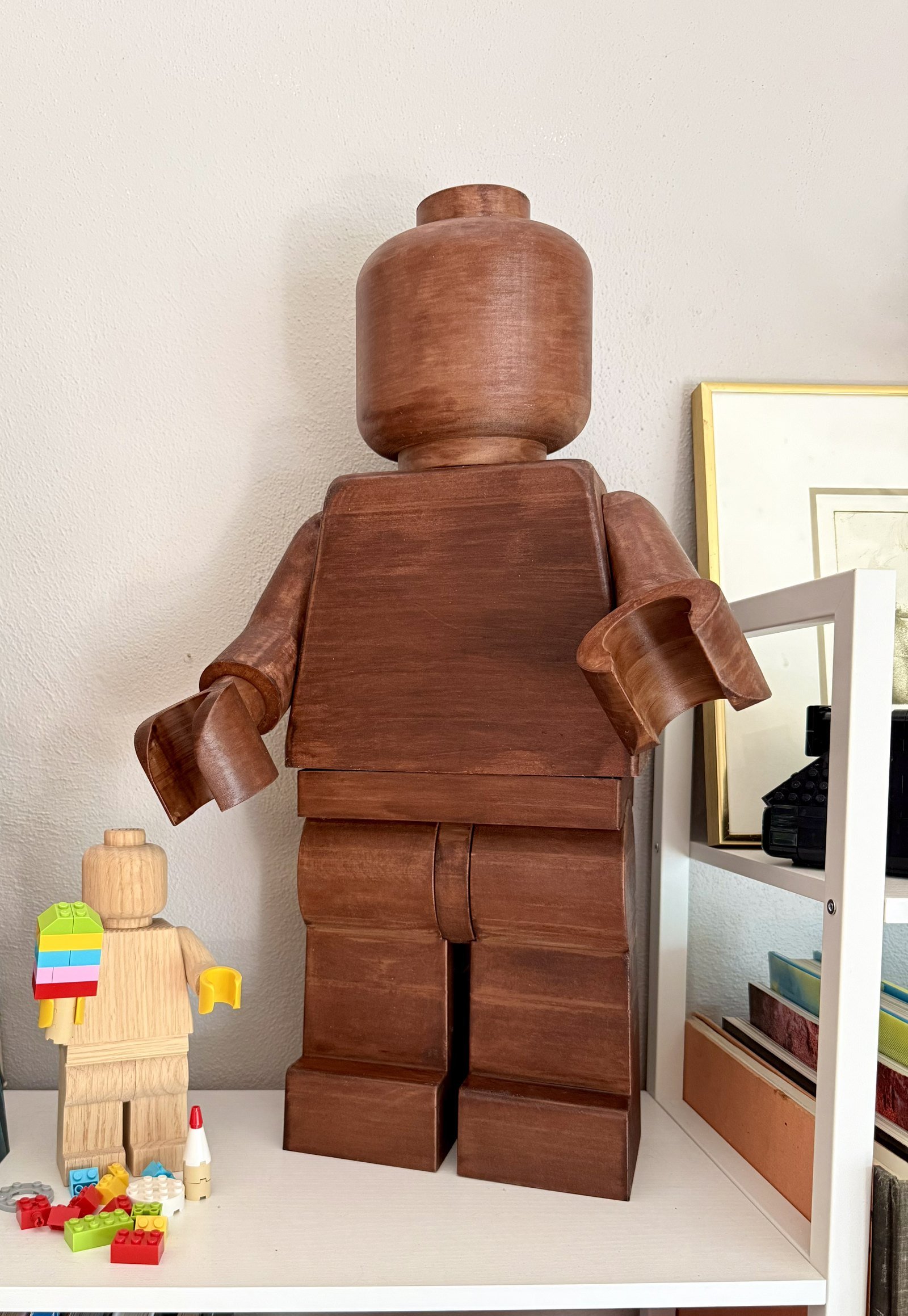 The Wood Edition beside a smaller unstained wood figure, showing what the American Walnut stain does to the grain